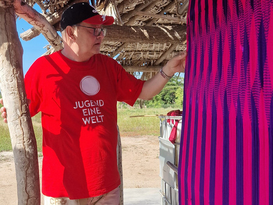 Jugend Eine Welt-Mitarbeiter Wolfgang Wedan bestaunt Kunsthandwerk Hängematte der Wayuu-Frauen